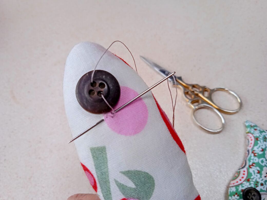 Sew on a button eye, step 4.