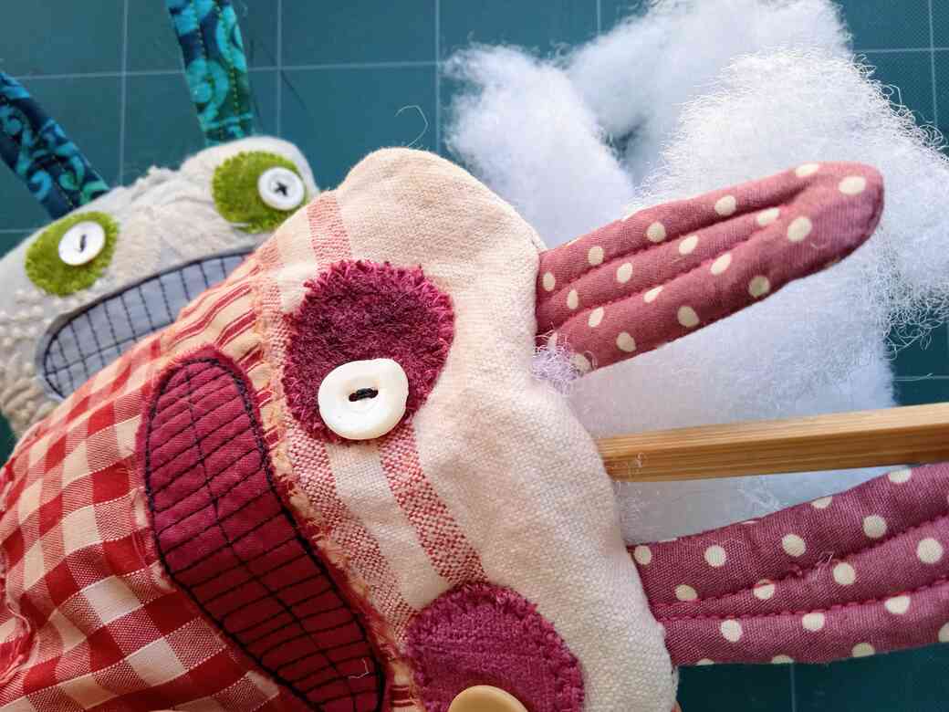 Stuffing monster doll using polyester fibre filling and a chopstick.