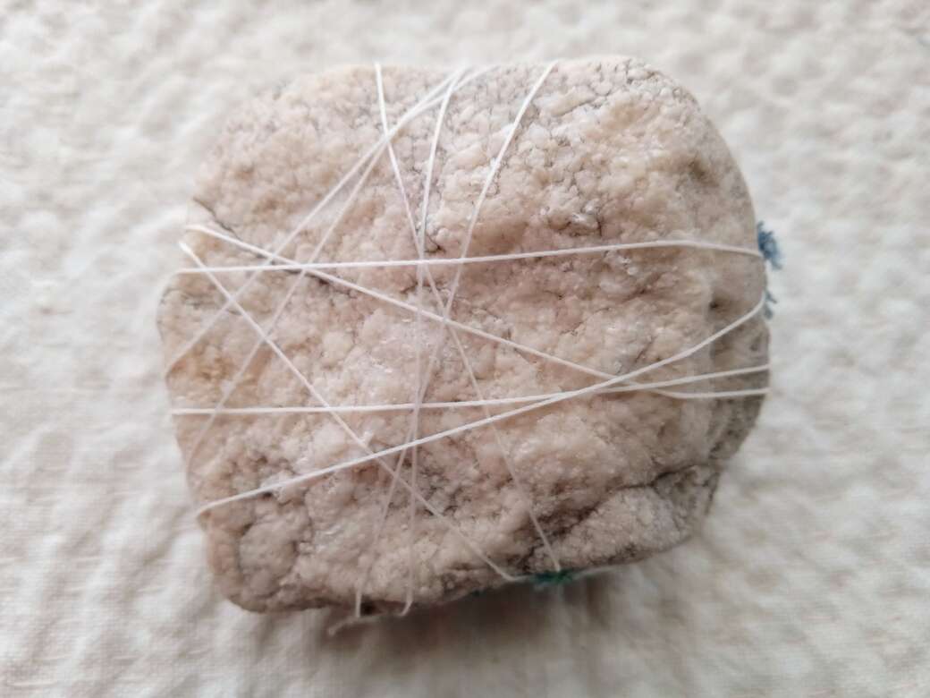 Thread forms a star pattern under rock