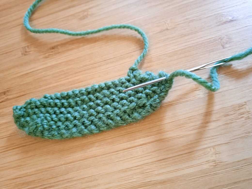 Wall Flowers, knitted flower, attach first leaf step 1.
