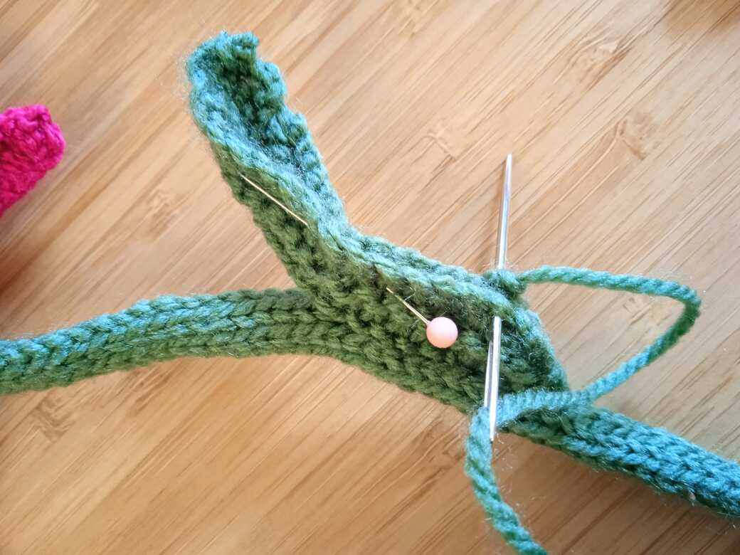 Wall Flowers, knitted flower, attach first leaf step 3.